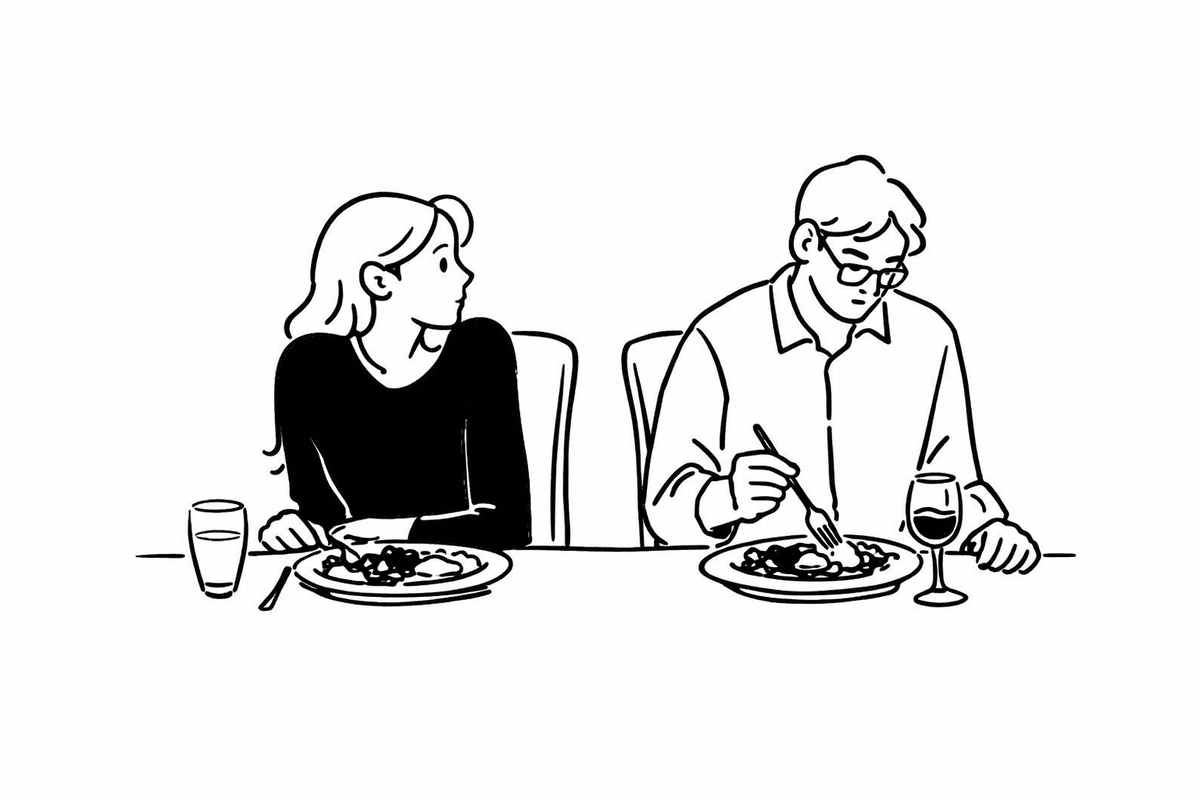 A couple sitting on opposite ends of a couch, both on their phones, not connecting